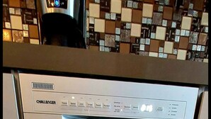 Una lavastoviglie in acciaio inossidabile in una cucina con zoccolo a mosaico.