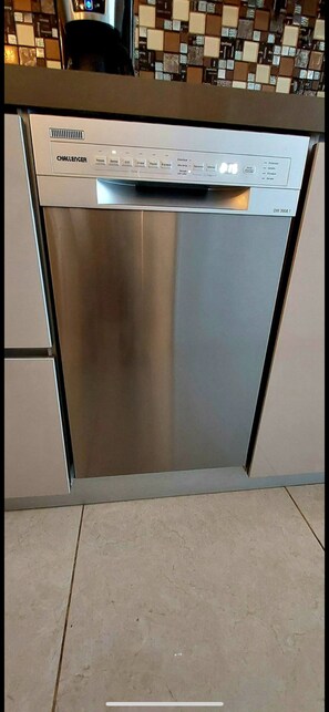 Eine Edelstahl-Geschirrspülmaschine in einer Küche mit gefliestem Fliesenspiegel.