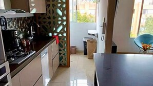 Una cucina moderna con una grande isola, forno a incasso e un divisorio decorativo.