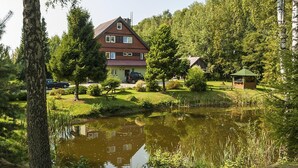 A house with a pond in front, surrounded by trees and a small gazebo. - Half of a Holiday Home, Huge Garden, Pond (gmina Stężyca)