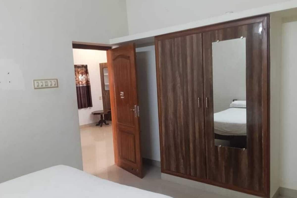 A bedroom with a bed, a wardrobe, and a mirror.