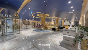 A modern hotel lobby with marble flooring, a reception desk, seating area, and decorative lighting. - Manzil-Waterfront Studio in Business Bay (Dubai)