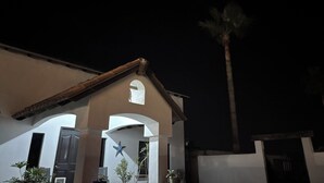 A building with a sloped roof, a star-shaped window, and a palm tree in the background. - Casa Vacacional Marqués (Playas de Rosarito)