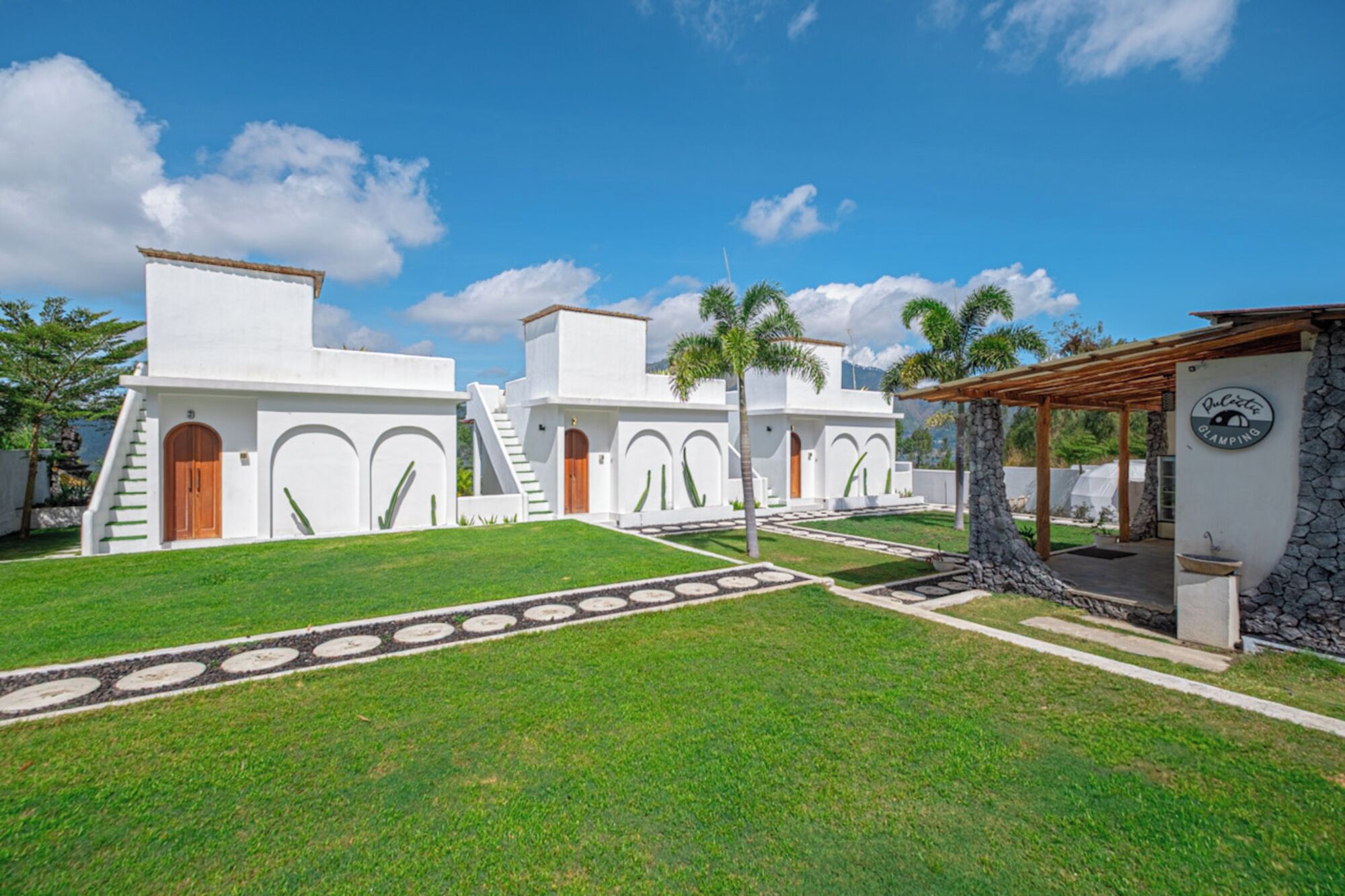 A modern building with white walls, multiple doors, and a covered outdoor area.