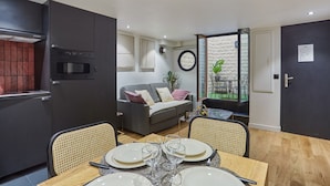A compact living space with a dining area, kitchenette, and a view of the outdoors. - Charming Apartment Faubourg St Honore Madeleine (Paris)