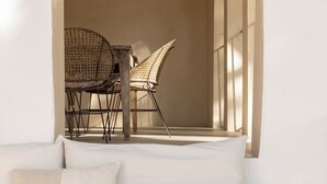 A cozy seating area with a bench and cushions, an arched doorway leading to a dining space with wicker chairs and a hanging light fixture. - Boutique Manor Farmhouse, pool & vineyard views, 35' Barcelona, 25' Sitges (Sant Pau d'Ordal)