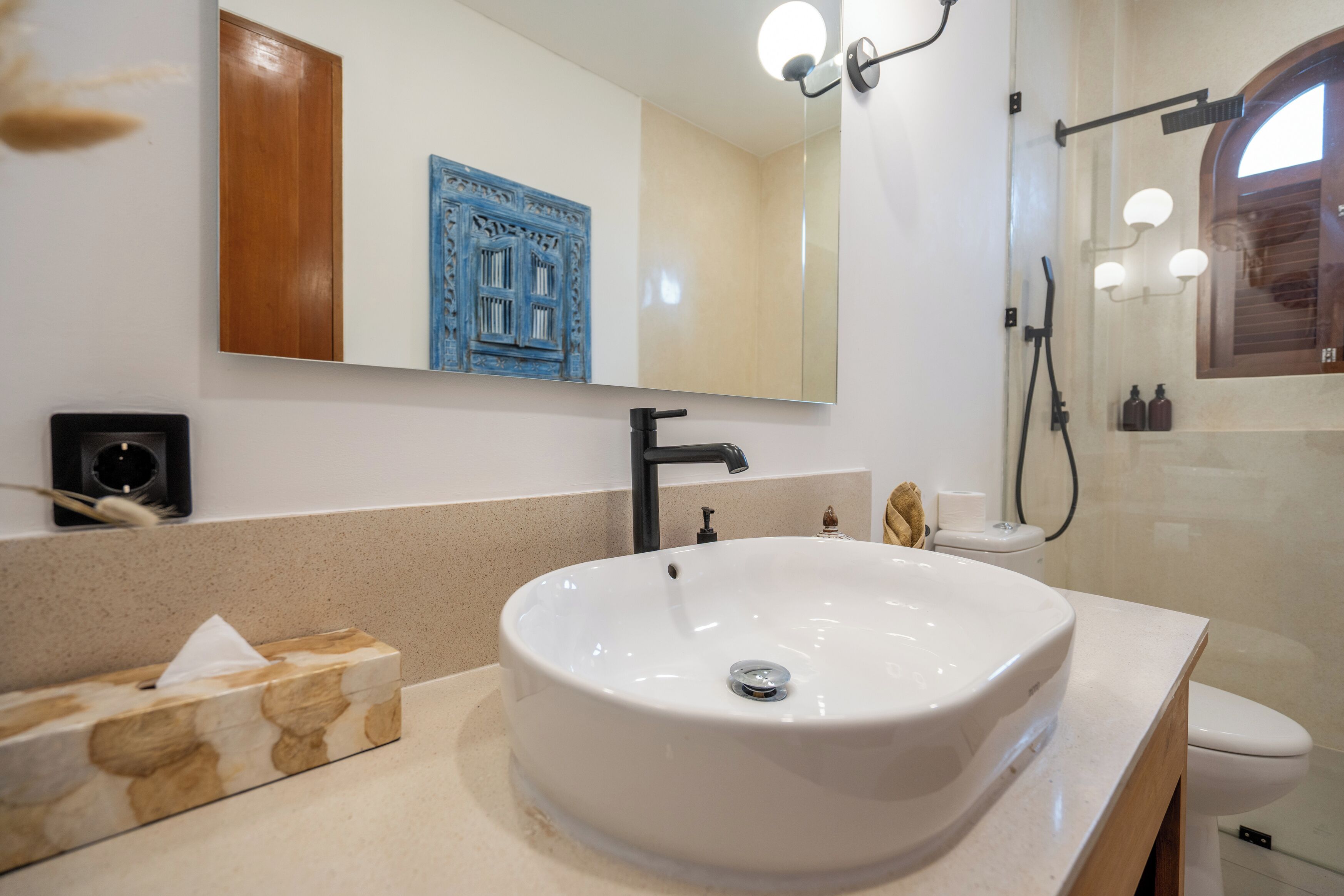 A bathroom with a white sink, a mirror, a towel, and a toilet.