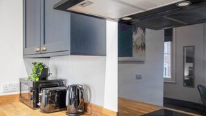 Eine moderne Küche mit Einbauofen, Kaffeemaschine und Toaster.