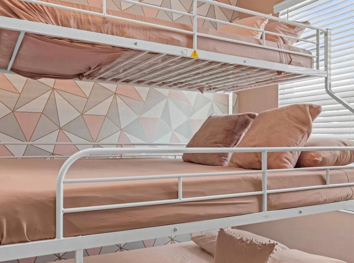 Un lit superposé à deux niveaux, chaque niveau étant équipé d’oreillers et d’un matelas.