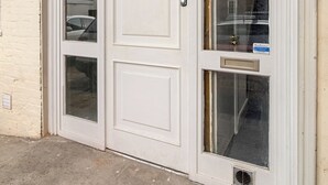 Una puerta doble blanca con paneles de vidrio y un letrero que dice "SHAW MEWS".