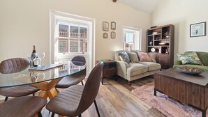 Un vaste espace de vie comprenant une table à manger en verre, des fauteuils en cuir, un canapé et une table basse.