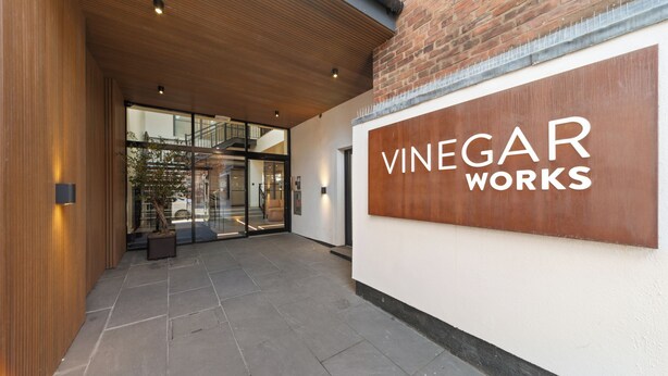 Une entrée moderne, ornée d’une enseigne indiquant : « Vinegar Works ».