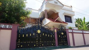 A two-story house with a black ornate gate and a red-tiled roof. - Vasantharaja Villa Ariyankuppam (Puducherry)