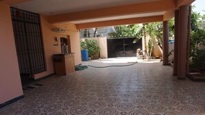 A spacious indoor area with patterned flooring, a water dispenser, and a hose. - Vasantharaja Villa Ariyankuppam (Puducherry)