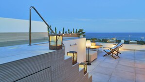 Eine Dachterrasse mit Pool, Sitzgelegenheit und Blick auf den Ozean.