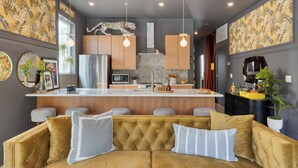 A modern kitchen with a central island, stainless steel appliances, and pendant lighting.