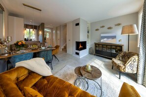 A modern living room with a fireplace, a dining area, and a sofa. - Haus Sylter Schönheit - Sylter Schönheit - Exclusive comfort in a prime location (Sylt Westerland)
