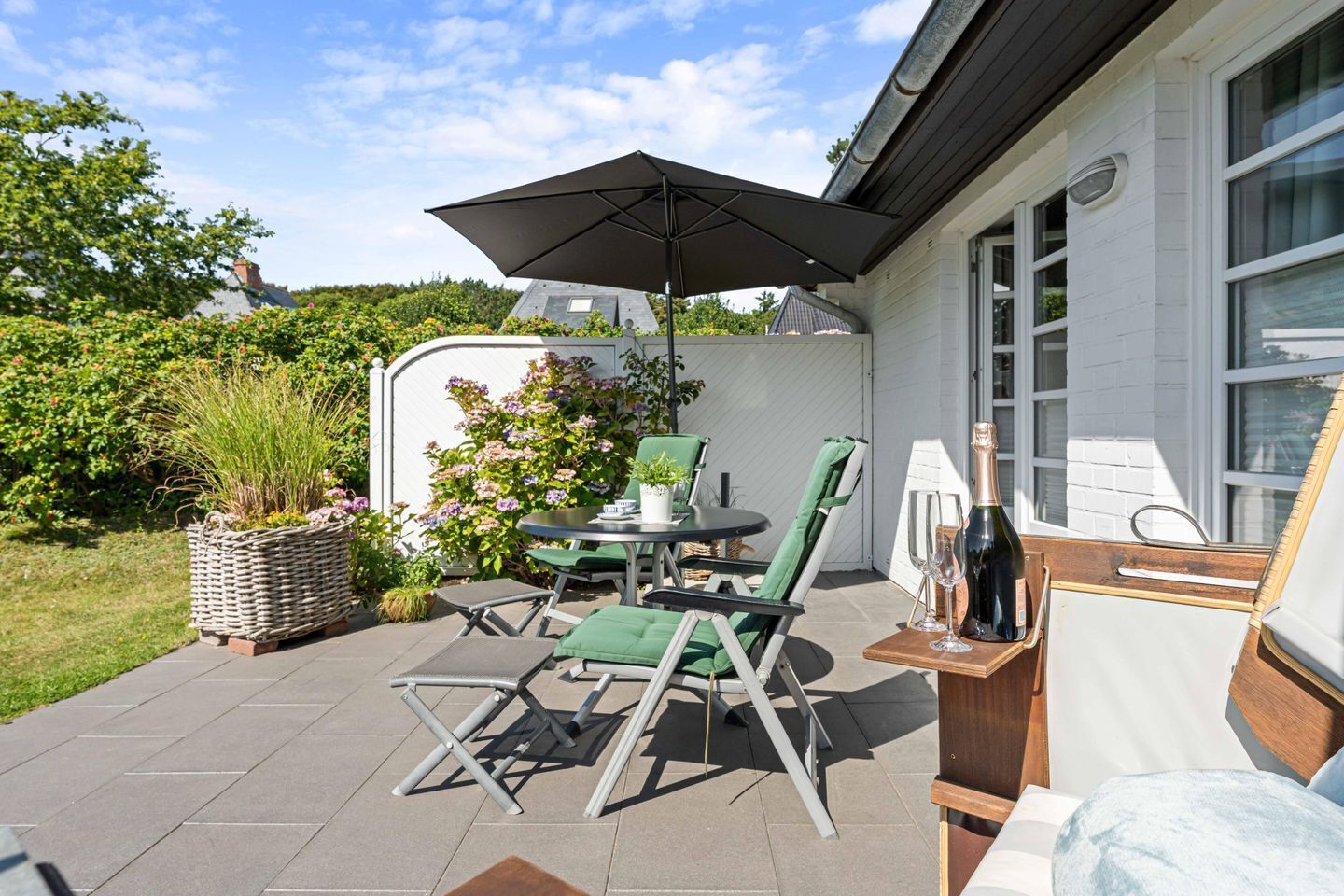 An outdoor patio with a table, chairs, and an umbrella.