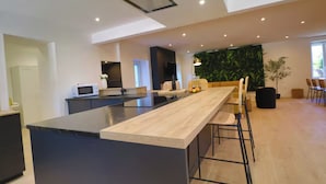 Una cocina moderna con una isla central, un comedor con sillas y un ventanal amplio.