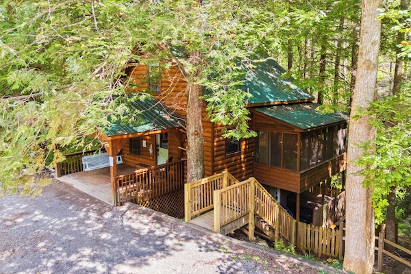 Escape to the woods in this rustic-chic cabin, complete with a cozy wraparound porch and an inviting sunroom for your morning coffee.