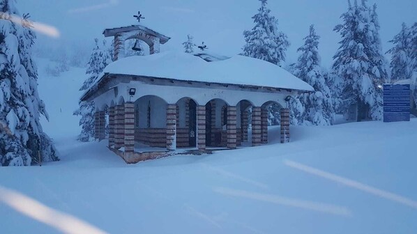 A snow-covered church with a bell tower and arched windows.