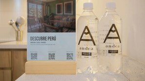 A sign for 'DESCUBRE PERÚ' with QR codes and two bottles labeled 'andea' with water. - w* | Seaside Studio near Malecon in Miraflores (Miraflores)