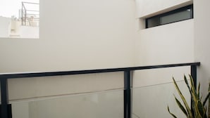 A modern building with a glass balcony, a metal railing, and a view of the cityscape. - w* | Seaside Studio near Malecon in Miraflores (Miraflores)