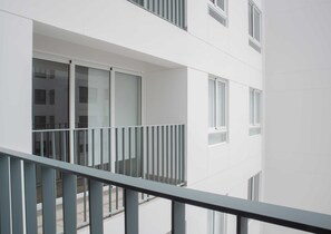 Een modern gebouw met een balkon en meerdere ramen.