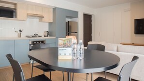 Una cocina moderna con zona de comedor, que incluye una mesa redonda, sillas y un sofá.