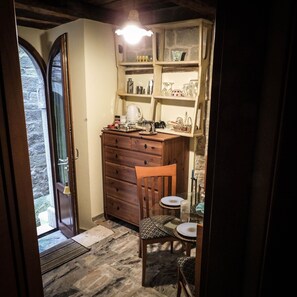Une petite cuisine avec un meuble en bois, une chaise et une table.
