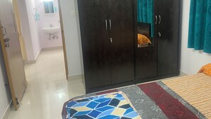 Quarto com cama, guarda-roupa, banheiro e espelho.