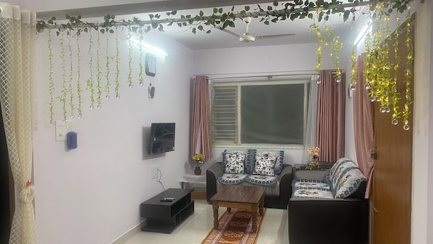Sala de estar com sofá, mesa de centro e televisão.