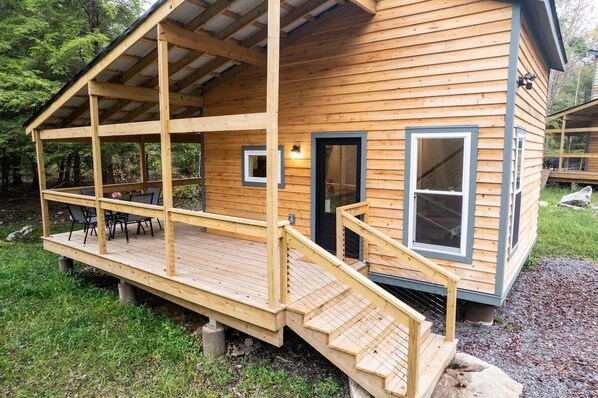 A wooden cabin with a covered porch, a staircase, and a door. - Sundew Cottage - Trailheads & Powder Days Await! (Davis)