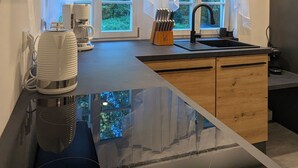 Une cuisine moderne dotée d’un grand îlot central, d’une machine à café et d’un bloc à couteaux.
