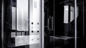 Un baño moderno con cabina de vidrio, lavabo y espejo.