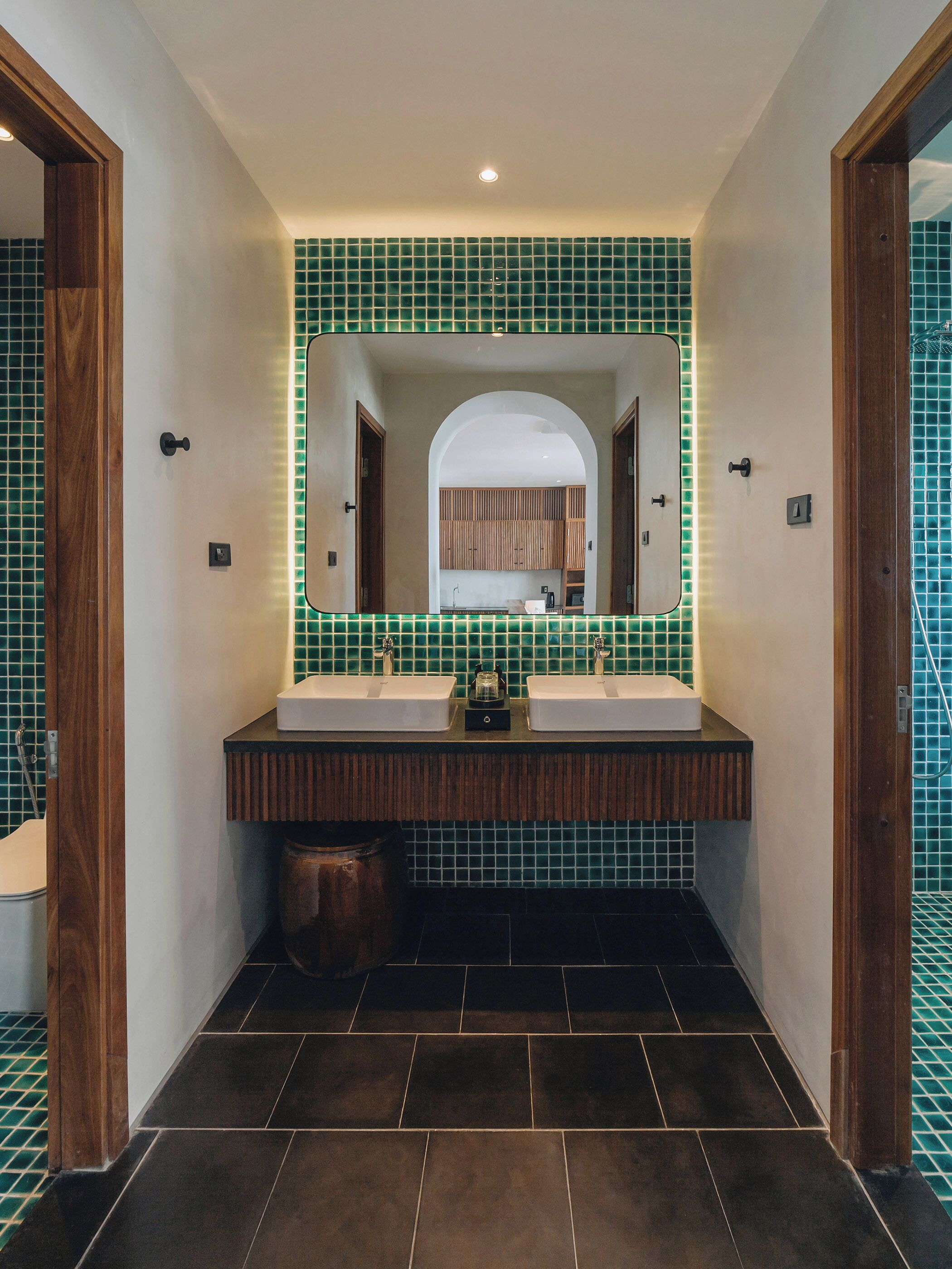 A modern bathroom with two sinks, a large mirror, and a tiled floor.