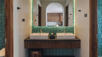A modern bathroom with two sinks, a large mirror, and a tiled floor.