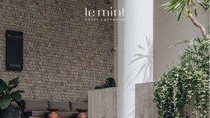 Un hall d’hôtel avec un mur en briques, un comptoir d’accueil, un canapé et un escalier.