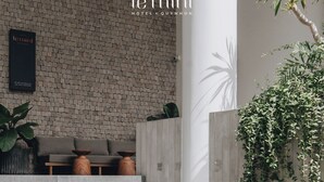 Un hall d’hôtel avec un mur en briques, un comptoir d’accueil, un canapé et un escalier.