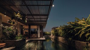 A modern hotel with a pool, surrounded by lush greenery and a covered outdoor area. - Le Mint Hotel Quy Nhơn (Quy Nhon Nam)