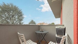 A small balcony with two white chairs, a small table, and a trash bin. - Girasole (A5) | Three-room apartment with two bathrooms | Rho Fiera | Malpensa | Milan (Cesate)
