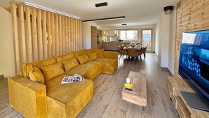 A modern living room with a sectional sofa, a wooden coffee table, and a flat-screen TV. - Luxury chalet in Vars, comfort for 8 guests, private parking (Vars)