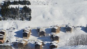 Ein schneebedecktes Dorf mit mehreren Chalets.