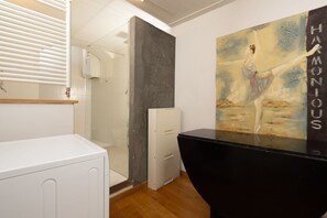 A modern bathroom with a white cabinet, a black countertop, and a painting of a dancer on the wall. - Florence Duomo Grand Apartment  (Florence)