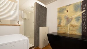 A modern bathroom with a white cabinet, a black countertop, and a painting of a dancer on the wall. - Florence Duomo Grand Apartment  (Florence)