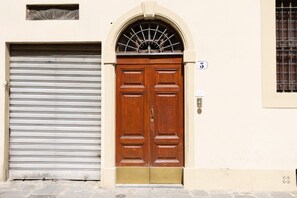 A double wooden door with a metal shutter to the left. - Florence Duomo Grand Apartment  (Florence)