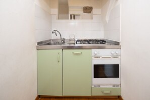 A compact kitchen with a sink, stove, and oven.