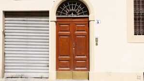 A double wooden door with a metal shutter to the left. - Florence Duomo Grand Apartment  (Florence)