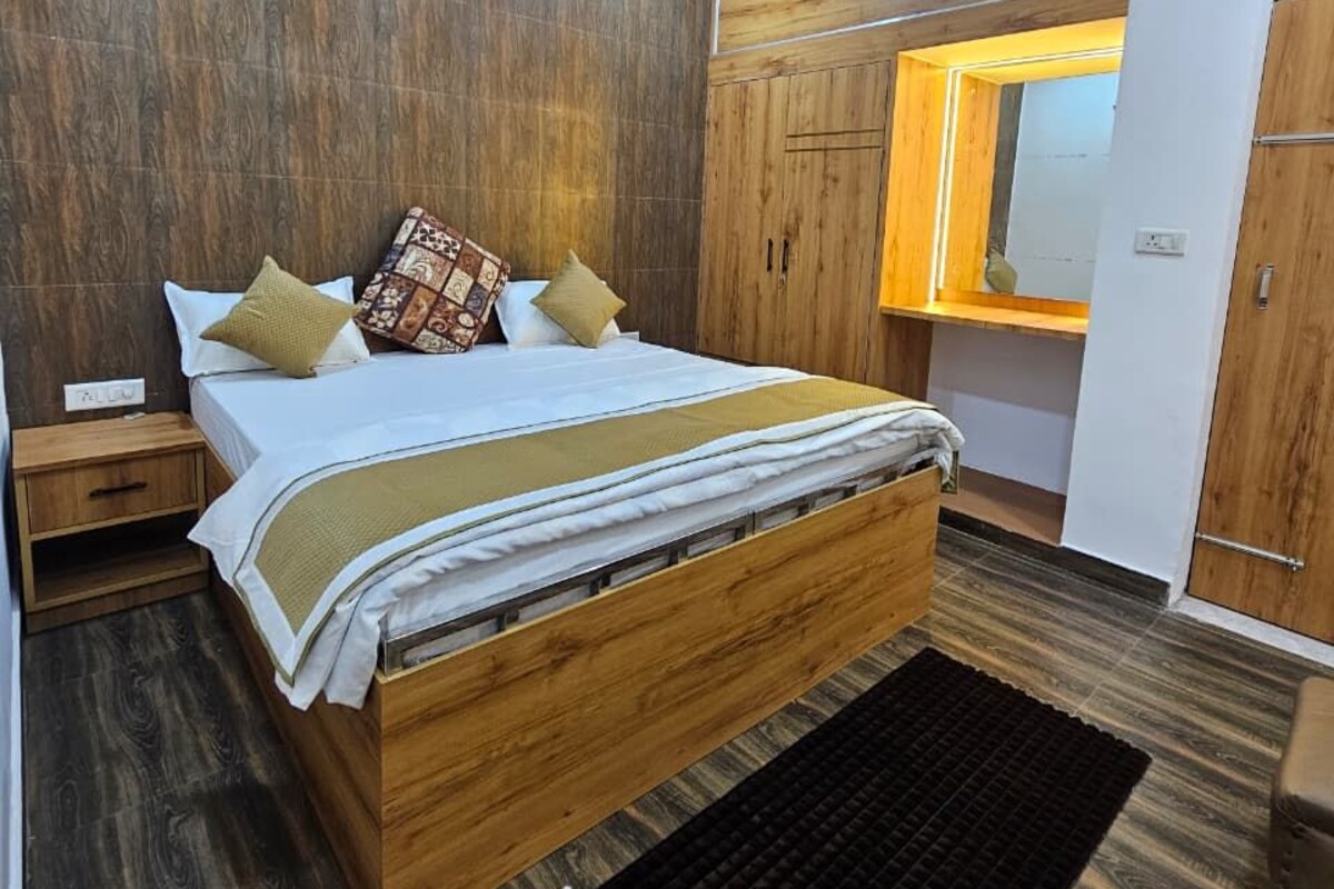 A bedroom with a wooden bed, a nightstand, a black rug, and a wardrobe with a mirror.