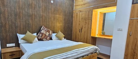 Un dormitorio con una cama de madera, una mesita de noche, un tapete negro y un armario con espejo.